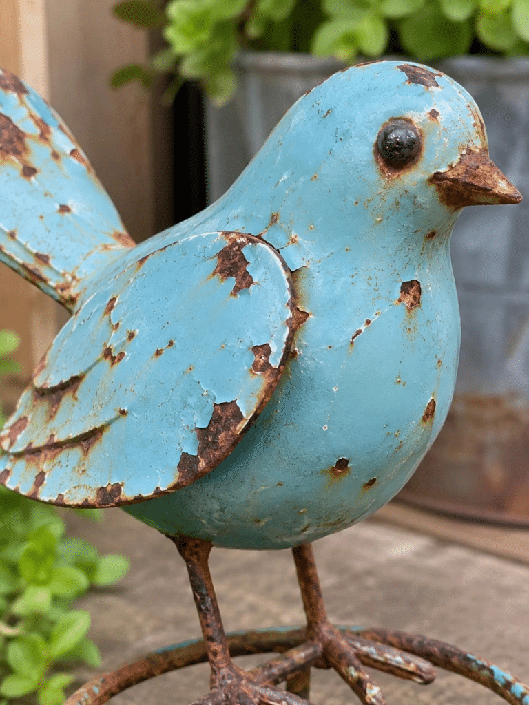 A close up of a cheap painted metal ornament showing visible rust spots and chipped paint.