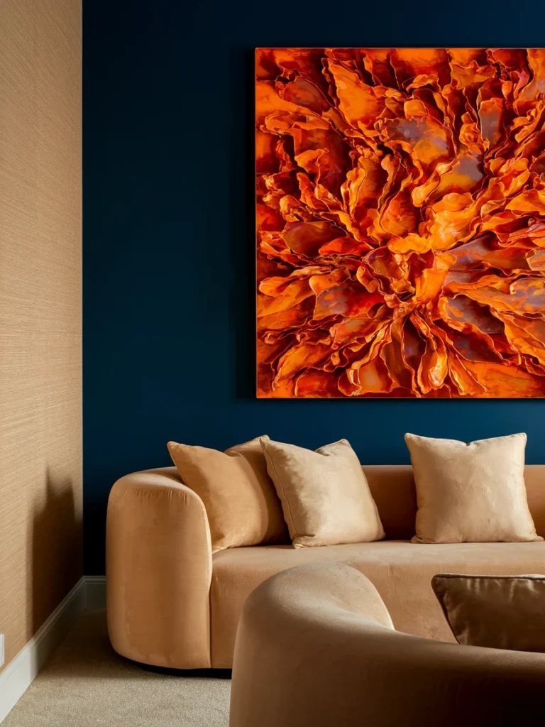 Navy accent wall in a blue and orange living room with large orange abstract art