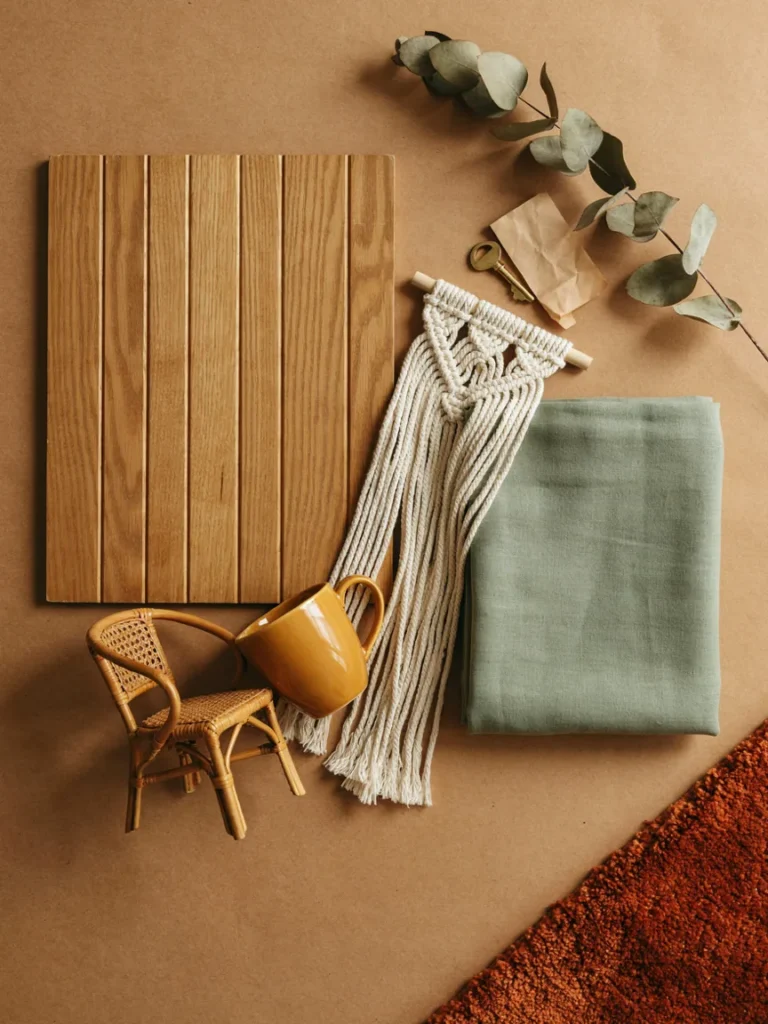 Collage style flat lay of iconic 70s design elements, wood paneling swatch, macrame wall hanging, avocado green fabric sample, and a small rattan chair, warm earthy styling